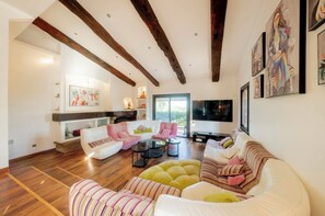 A spacious living room with a fireplace, a television, and a large window. - Family villa for 15 people with a playground, pool, and large hot tub! Ocean view!  (Tourrettes-sur-Loup)