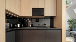 Una cocina moderna con armarios de madera, encimera negra y estufa empotrada.