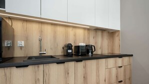 Eine moderne Küche mit Holztresen, Spüle, Kaffeemaschine und Wasserkocher.