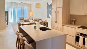 Uma cozinha moderna com ilha central, armários de madeira e eletrodomésticos embutidos.