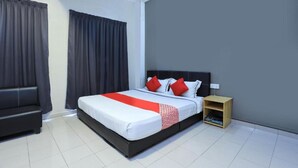 Una habitación de hotel moderna con una cama grande, cortinas oscuras, una mesita de noche de madera y un sofá negro.