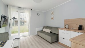 Un salon moderne et épuré, avec un canapé, une table basse et un bureau en bois.