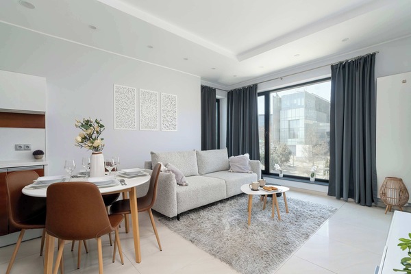 Cozy and bright living room with a sofa, TV, coffee table and other decorative elements.