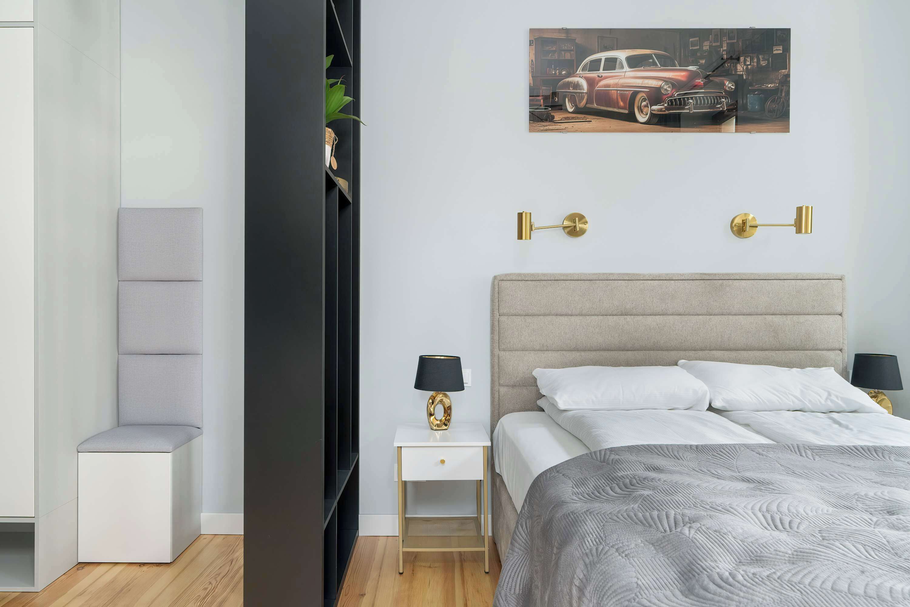 A modern bedroom with a bed, nightstands, a chair, and a wall-mounted lamp.