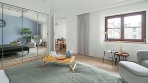 A modern living room with a glass partition, a dining area, and a view of the city through a window. - Spacious Apartment in the Center | Two Bedrooms | Desk. (Poznań)