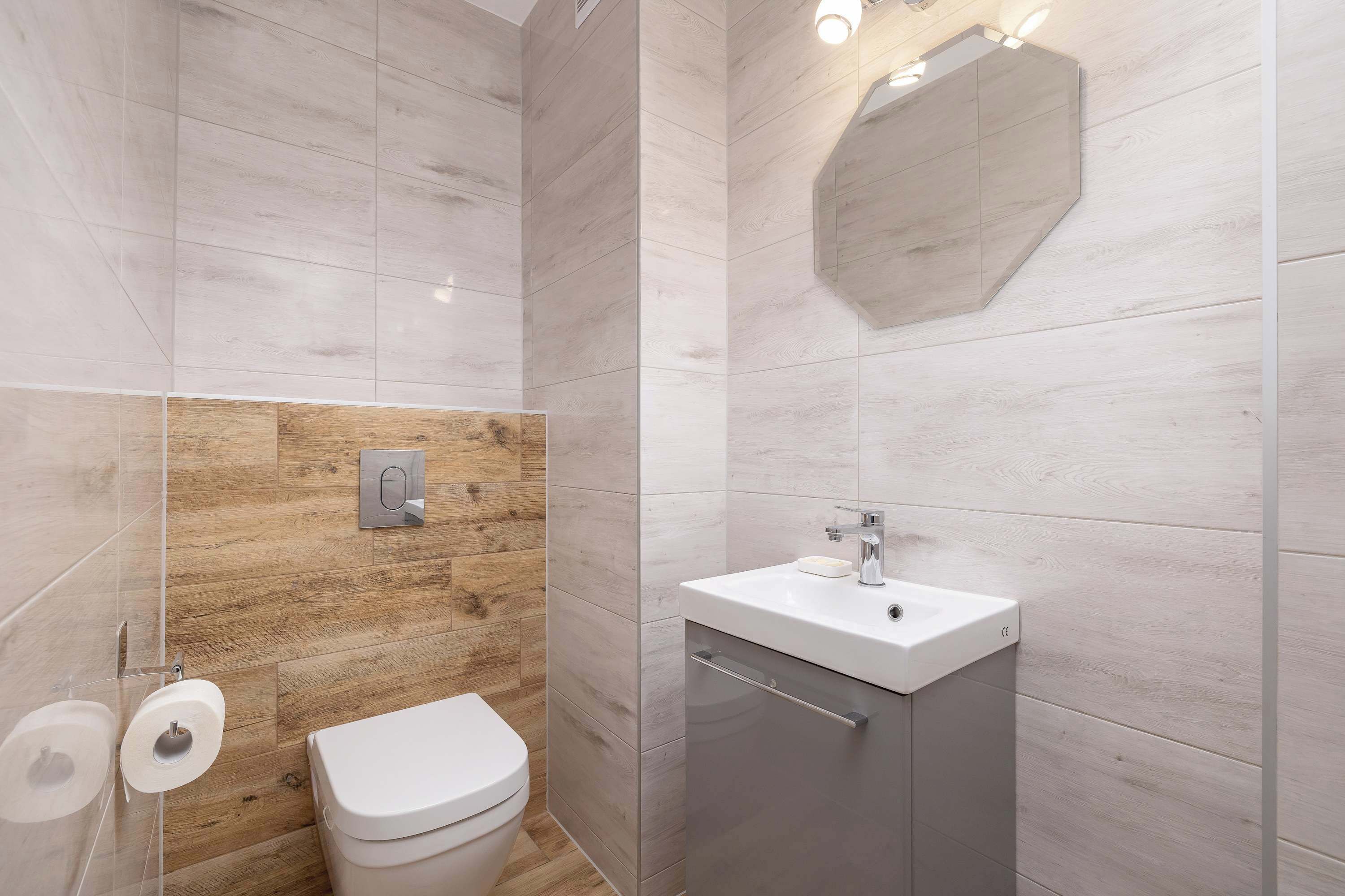Ein modernes Badezimmer mit Toilette, Waschbecken und Spiegel.