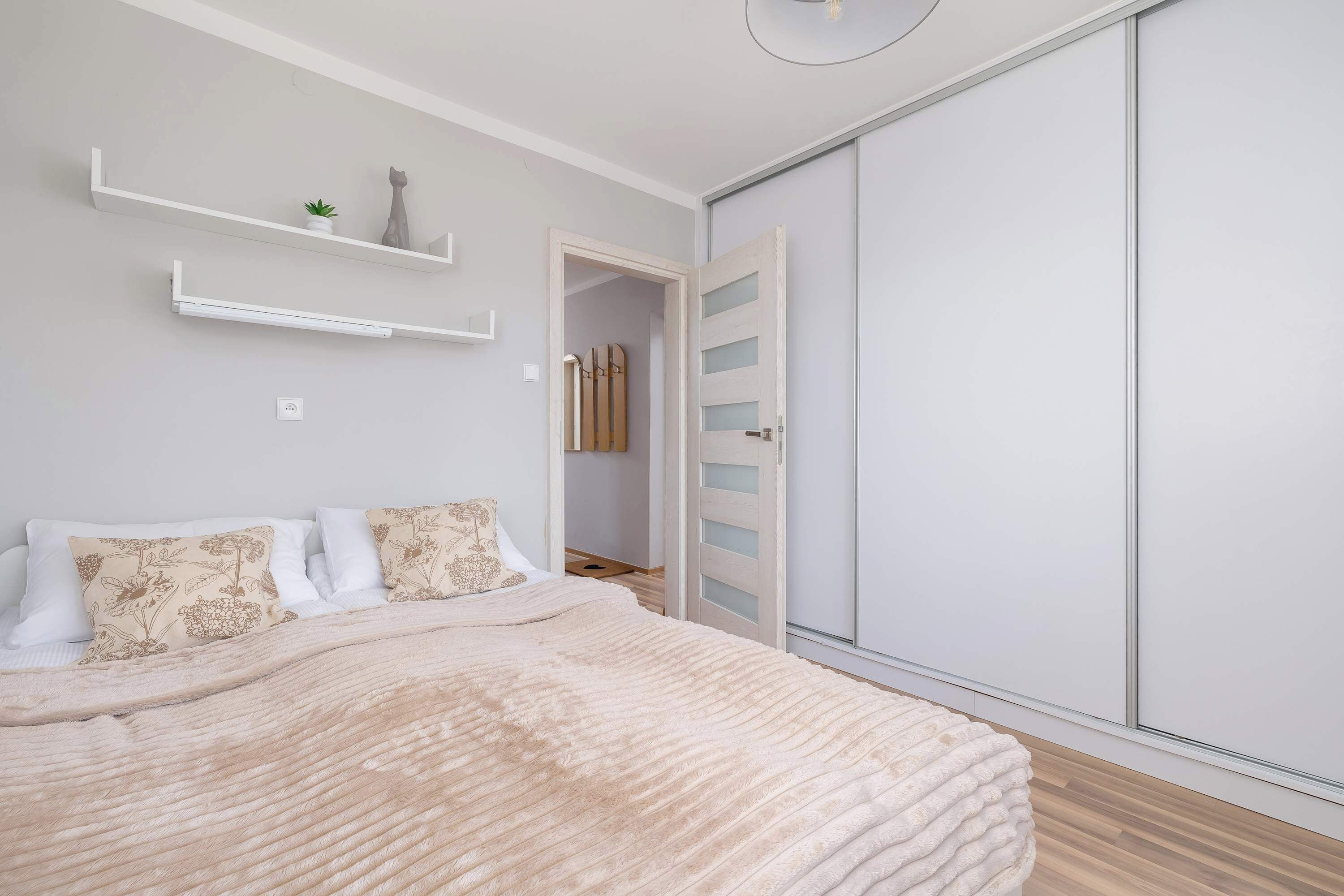 Une chambre à coucher comprenant un lit, une armoire et une porte donnant sur une salle de bain.