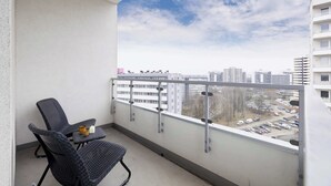 Un balcón con vista a un estacionamiento y edificios.