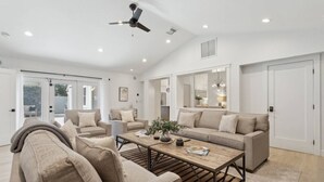 A spacious living room with a high ceiling, a ceiling fan, and a large window providing natural light. - Scottsdale Oasis | Heated Pool | Spa | Grill (Scottsdale)