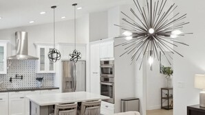 A modern kitchen with a central island, pendant lights, and a unique ceiling light fixture. - Scottsdale Oasis | Heated Pool | Spa | Grill (Scottsdale)