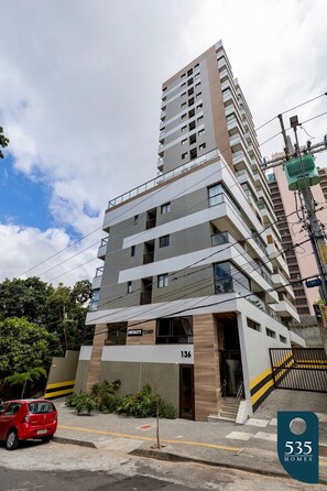 A multi-story building with a modern design, featuring balconies and a prominent entrance. - Comfortable Studio in Caminho das Árvores (Salvador)