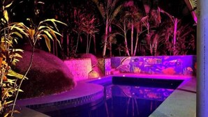 Piscina com borda azulejada e um mural na parede.