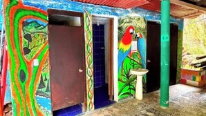 Quarto com murais coloridos, piso de azulejos e uma única porta.