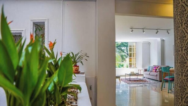 A modern living room with a sofa, a coffee table, and a view of the outdoors.