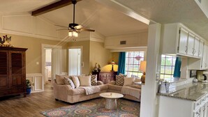 A spacious living room with a beige sectional sofa, a patterned rug, and a ceiling fan. - Beautiful country home escape for a Country Christmas in Bellville, TX (Bellville)