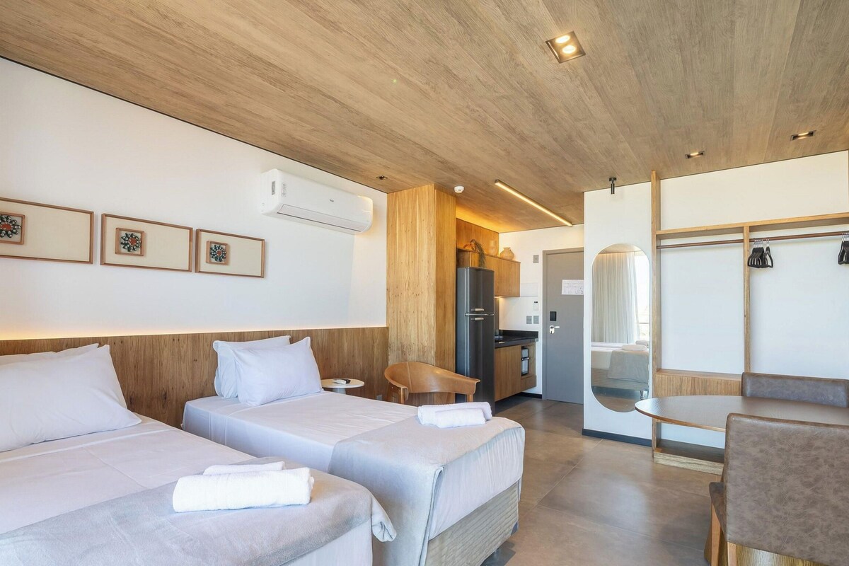 Ein Hotelzimmer mit zwei Betten, einem Essbereich und einem Badezimmer.