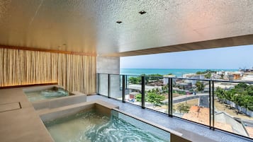 Piscina interior moderna con vistas al océano y al paisaje urbano.