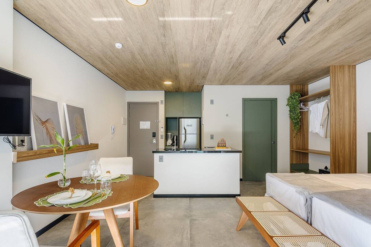 A modern, compact living space with a kitchen, dining area, and a sofa.