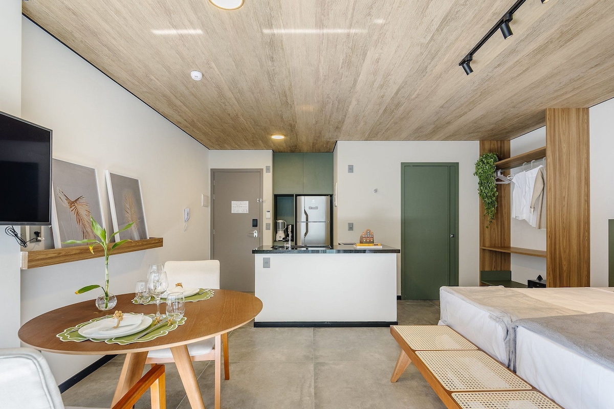 A modern, compact living space with a kitchen, dining area, and a sofa.