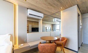A modern hotel room with a sofa, a round table, and a TV mounted on a wall. - Nwts - Studios in Building With Sea View (Maceió)
