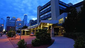 A medical center building with a covered entrance, surrounded by urban buildings and a clear sky. - Coze Studio Unit Near Downtown MN and Airport (Minneapolis)