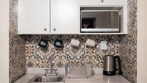 A kitchen with a microwave, sink, and coffee maker.