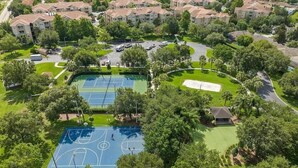 Vue aérienne d’un quartier résidentiel comprenant plusieurs immeubles d’appartements, un court de tennis et un terrain de golf.