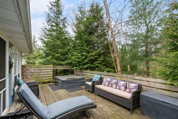 A wooden deck with outdoor furniture including a sofa, two lounge chairs, and a hot tub. - "cozy Cottages" Blue Cottage-hot Tub/town! (Saugatuck)