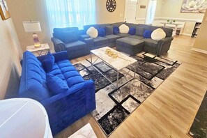 Un salon avec un canapé d’angle, une table basse et un tapis.