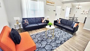 Ein modernes Wohnzimmer mit zwei Sofas, einem Couchtisch und einem Teppich.