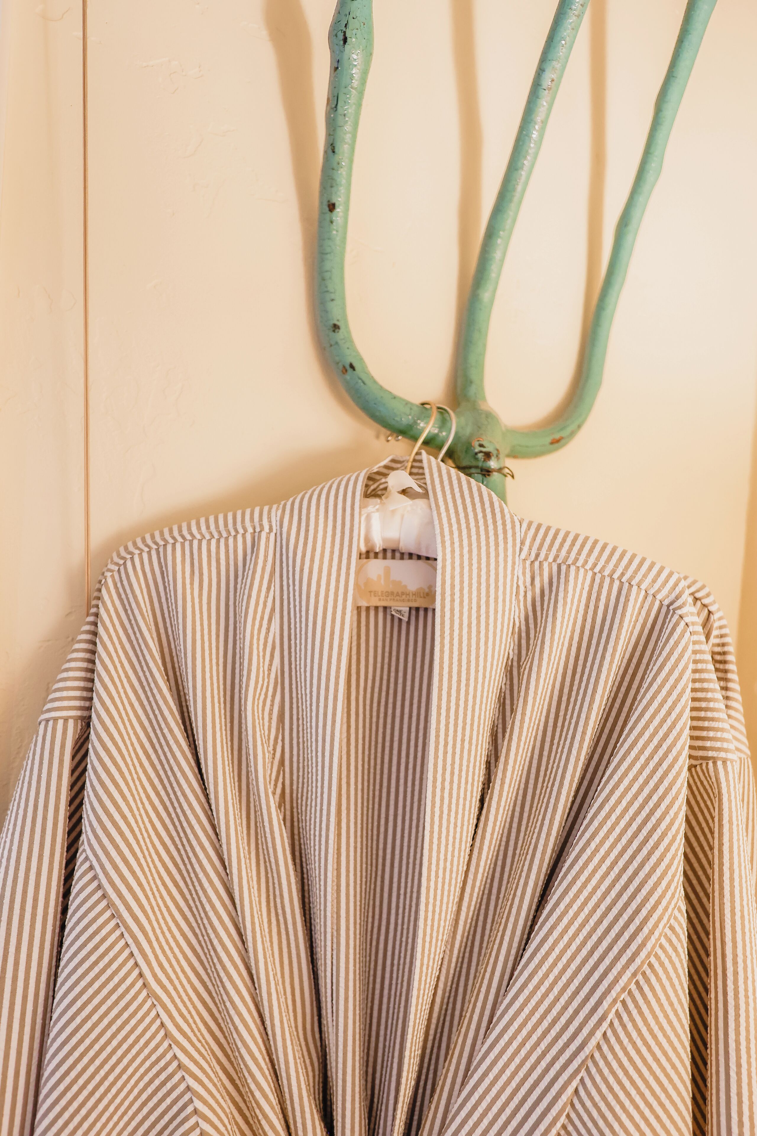 A striped garment hanging on a wooden wall.