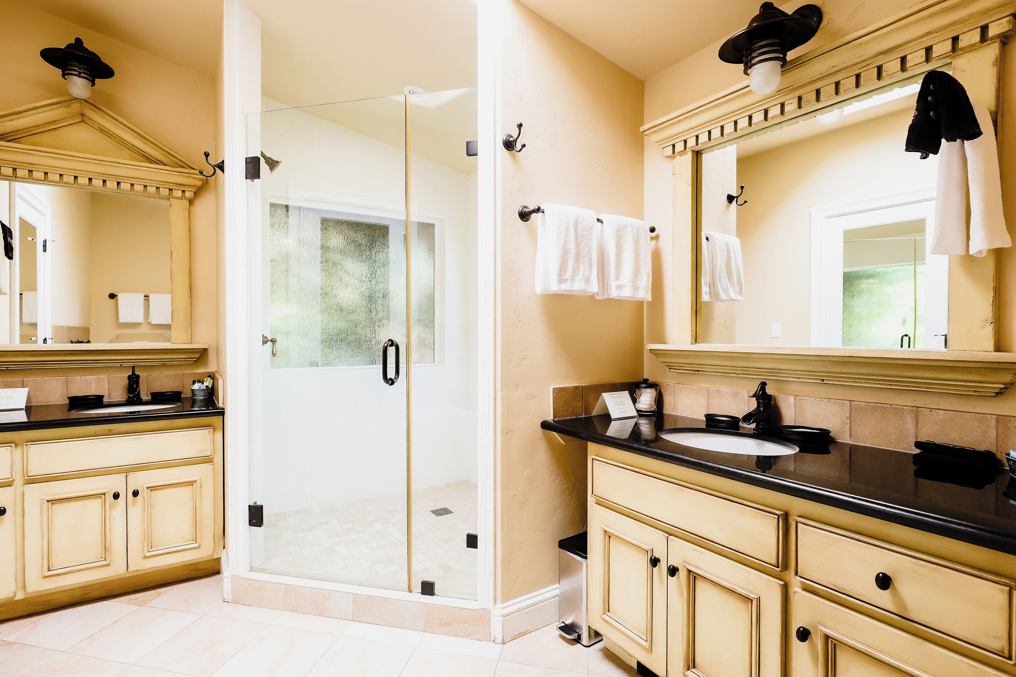 Un baño con cabina de ducha de vidrio, un lavabo y un mueble de tocador con espejo.