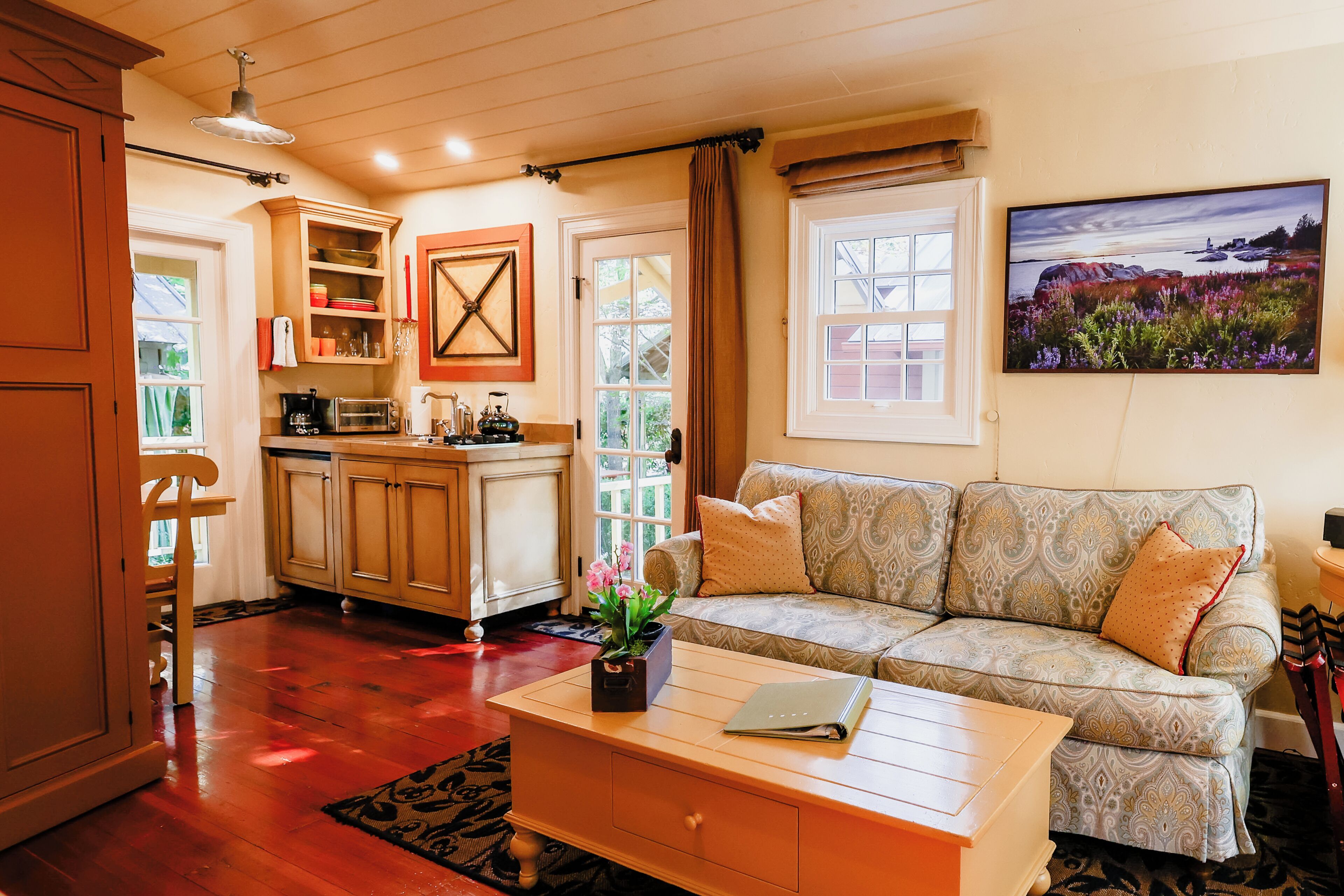 A cozy living room with a sofa, a coffee table, and a painting on the wall.