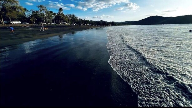 A beach with a clear sky and calm sea. - 2-bedroom condo in beautiful Playa Del Coco.  5 minute walk to beach (Guanacaste Province)