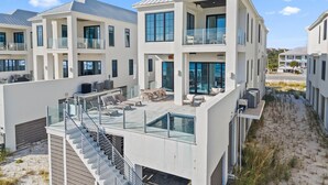 Ein modernes, mehrstöckiges Gebäude mit Dachterrasse, großen Fenstern und einer Treppe zu den oberen Etagen.