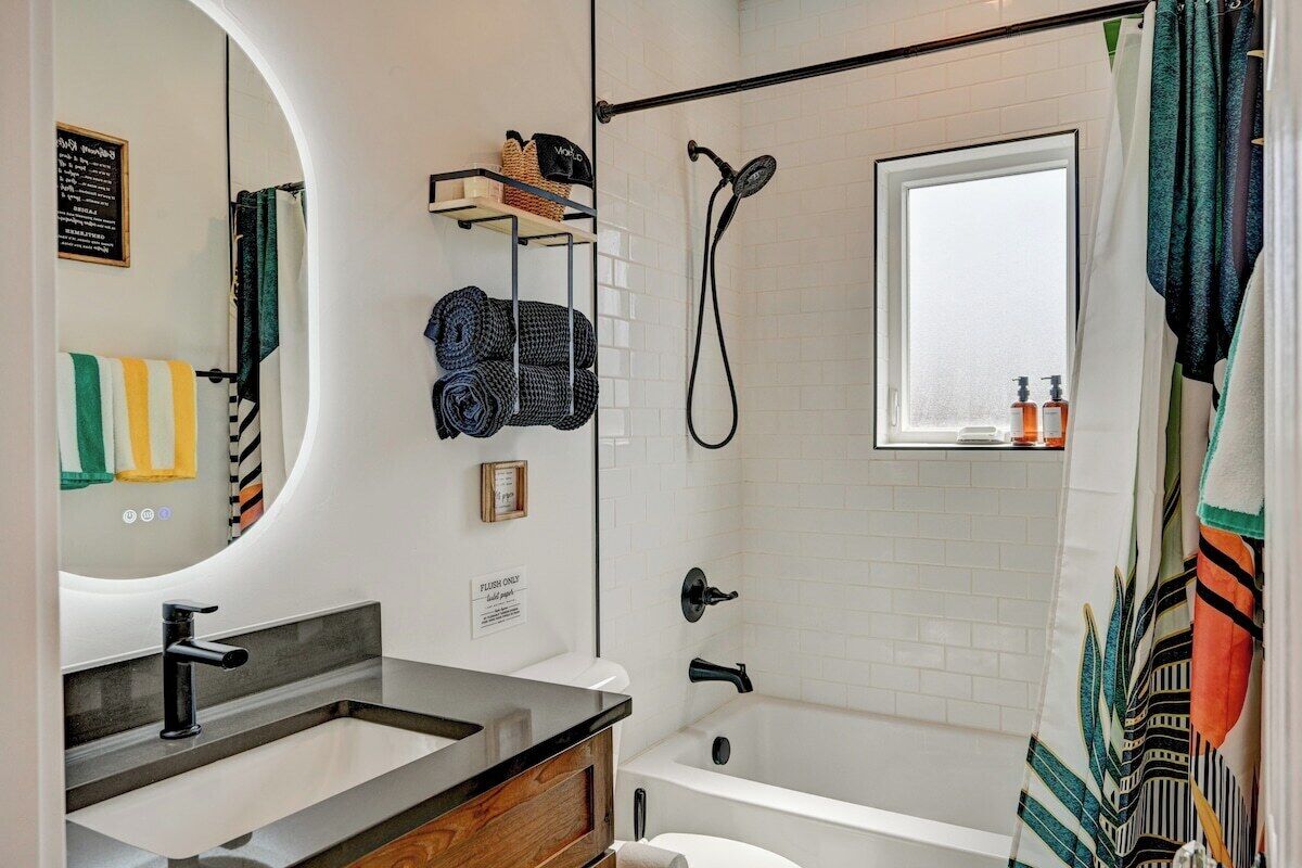 Une salle de bain moderne avec un lavabo, un miroir et une douche.