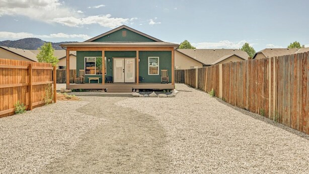A single-story building with a porch, a front door, and a small set of stairs leading up to the entrance.