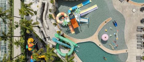 An aerial view of a water park with slides, pools, and a play area.