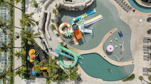 Vista aérea de un parque acuático con toboganes, piscinas y una zona de juegos.