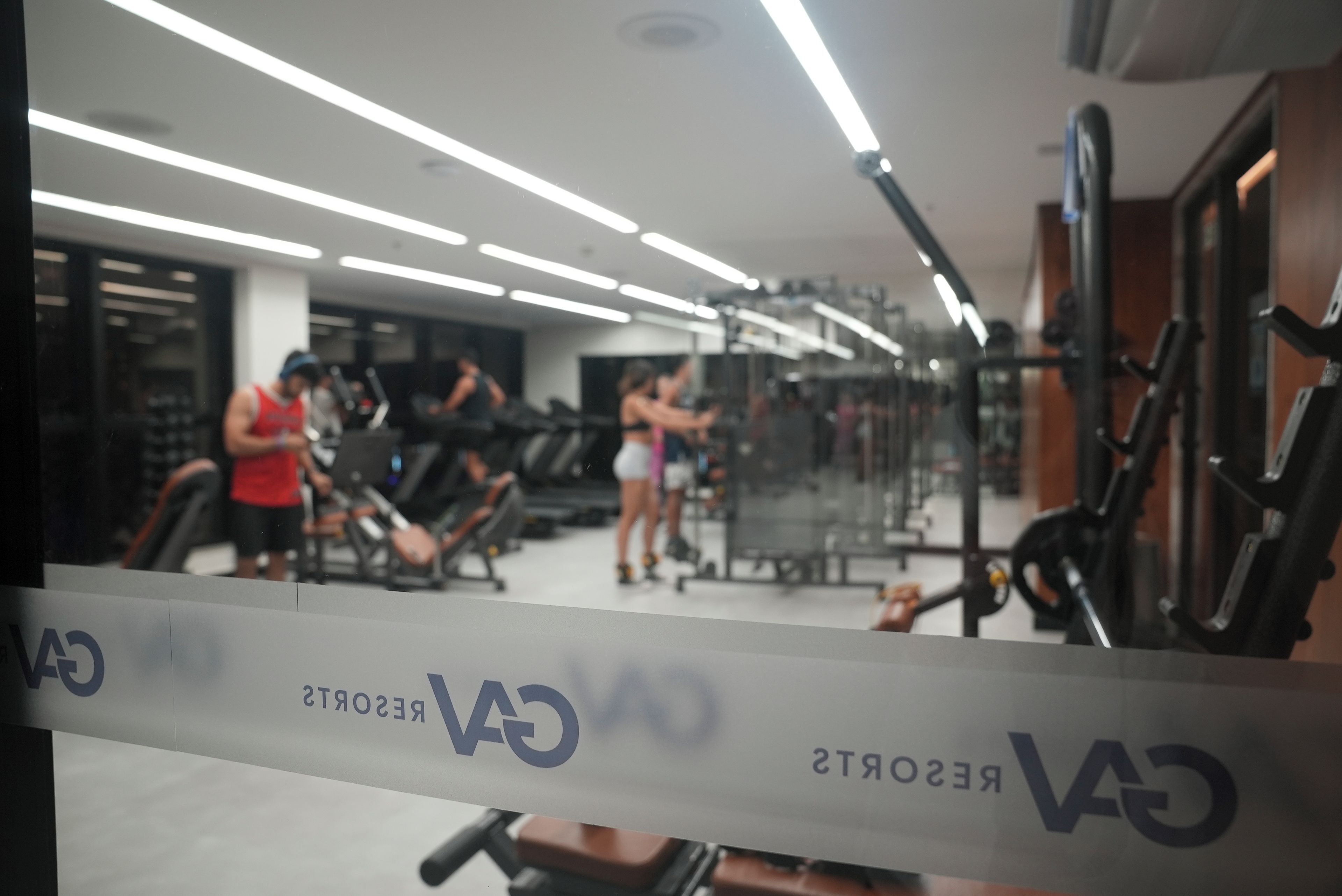 Een sportschool met trainingsapparatuur, een spiegel en een bord waarop 'CARS' staat.
