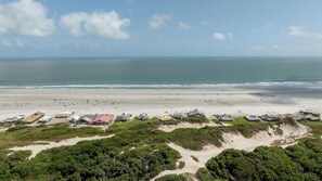 Una zona costera con una playa, varios edificios y un cielo despejado.