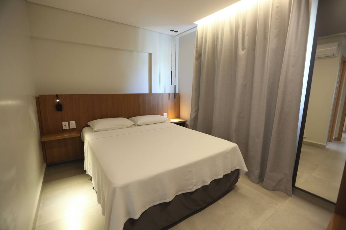 Ein Hotelzimmer mit Bett, Nachttisch und Spiegel.