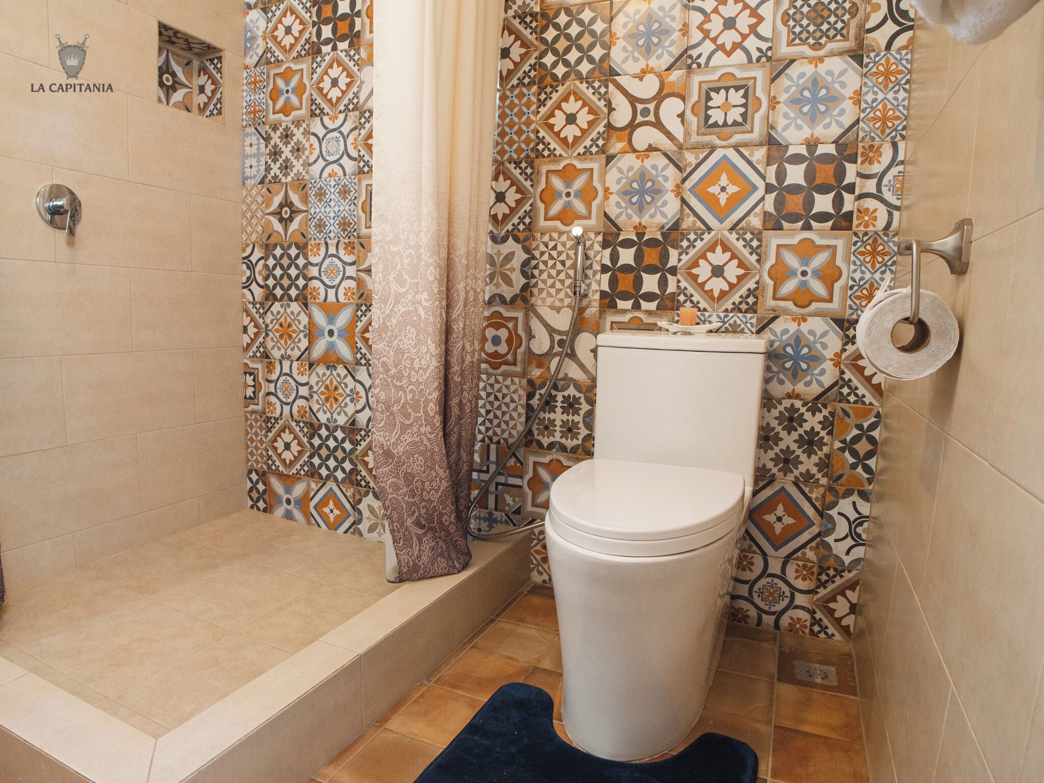 A bathroom with a toilet, shower, and tiled walls.