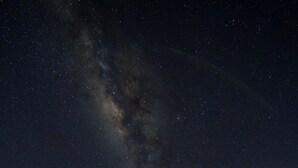 A night scene with a starry sky, a visible Milky Way, and thatched-roof structures with wooden interiors. - Sachakuna Resort (Sauce)