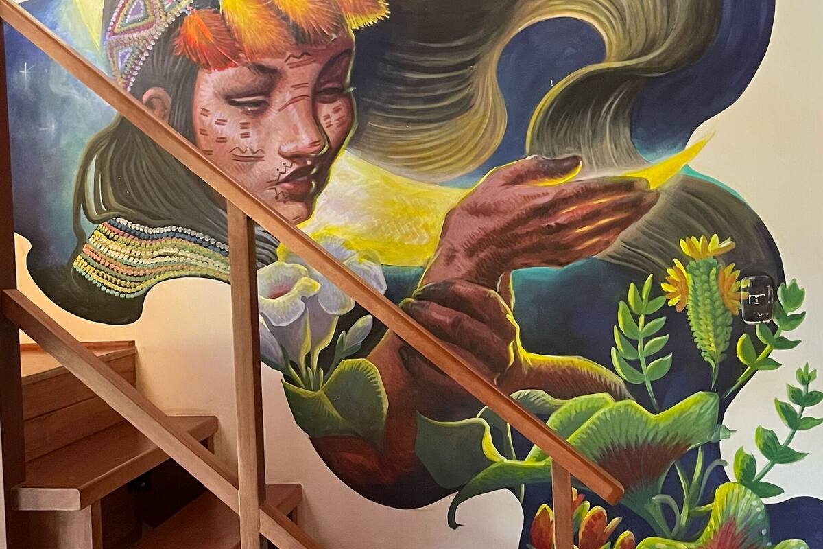A staircase with a mural featuring a woman, flowers, and a hummingbird.
