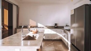 Una cucina moderna con un'isola grande, elettrodomestici in acciaio inossidabile e un design minimalista.