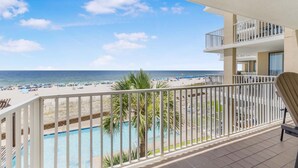 A balcony with a view of the beach and pool. - Romar Place 302 (Orange Beach)