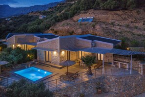 A modern villa with a swimming pool, outdoor seating, and solar panels. - Pyrgos Plakias Villas (Agios Vasileios)