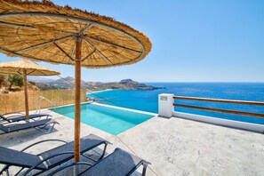 Een buitenzwembad, parasols voor strand/zwembad