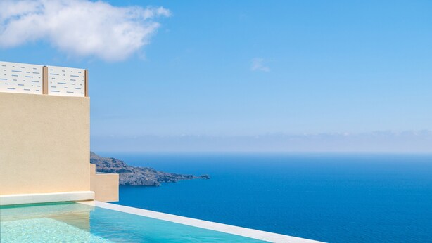 A clear blue sky, a swimming pool, and a distant view of the sea. - Pyrgos Exquisite Villas (Agios Vasileios)